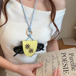 Vue détaillée du collier porte-lunettes rétro en cuir avec motif de tournesol brodé