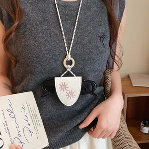 Vue détaillée d'un collier porte-lunettes en cuir blanc vintage avec motif soleil
