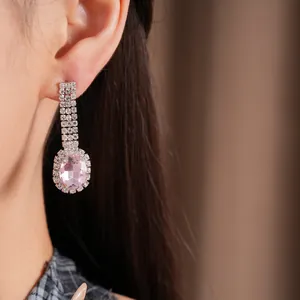 Detailaufnahme eleganter rosa ovaler Edelstein-Ohrhänger mit funkelnden Strasssteinen.