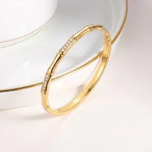 Gedetailleerde opname van een gouden bamboe armband ingelegd met fonkelende zirkoon
