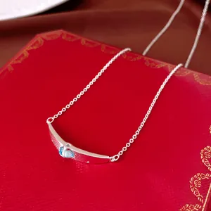 Primo piano di un'elegante collana in argento con pendente in zircone blu su scatola