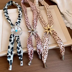 Close-up of leopard print cloth necklaces with metallic flower pendants and star tips