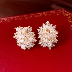 Nahaufnahme von eleganten facettierten Kristall-Cluster-Ohrsteckern mit Goldakzenten