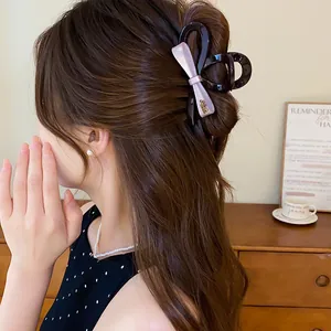 Detail van een elegante roze strik haarklem van acryl gestyled op het haar van een vrouw