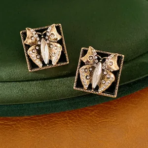 Nahaufnahme von Vintage quadratischen Schmetterlingsohrringen mit Emaille und Steinen