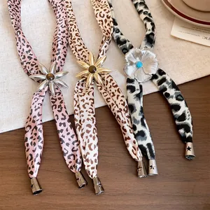 Close-up of fabric leopard print necklaces with resin flower pendants in three colors