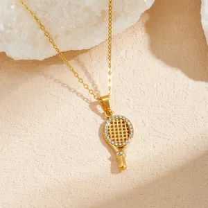 Close-up of gold-plated tennis racket pendant necklace with sparkling rhinestone details