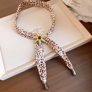 Close-up detail of leopard print fabric necklace with elegant gold flower centerpiece