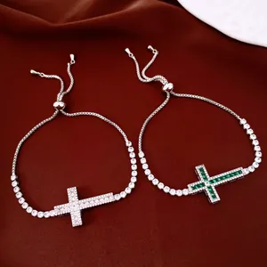 Gros plan de bracelets croix élégants avec zircons cubiques verts et blancs