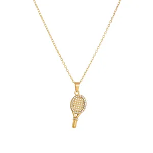 Detailed view of gold-plated tennis racket pendant with sparkling rhinestones