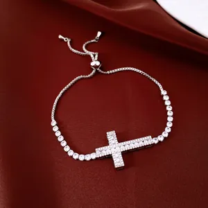 Gros plan d'un bracelet ajustable en argent avec une croix sertie de zircons brillants