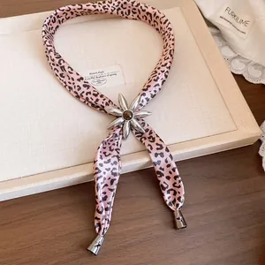 Detailed view of a pink leopard fabric necklace with a silver resin flower slider.