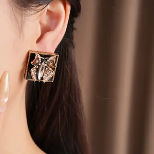 Nahaufnahme eines Vintage-Ohrrings mit schwarzer Emaille und Strass-Schmetterling