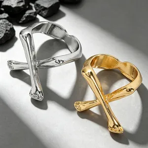 Nahaufnahme von abstrakten Metallringen mit gekreuztem Gliedmaßen-Design in Silber und Gold
