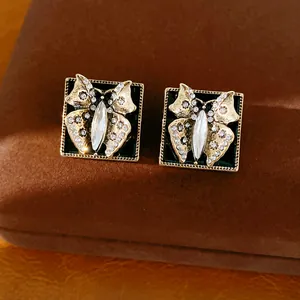 Detailansicht quadratischer Vintage-Schmetterlingsohrringe mit Emaille und glänzenden Strasssteinen