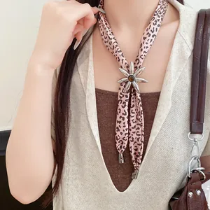 Leopard print fabric necklace with metallic flower resin pendant on model detail