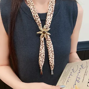 Close-up of leopard print fabric necklace with gold resin flower pendant detail