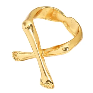 Nahaufnahme eines einzigartigen Goldrings mit abstraktem, gekreuztem Gliedmaßen-Design.