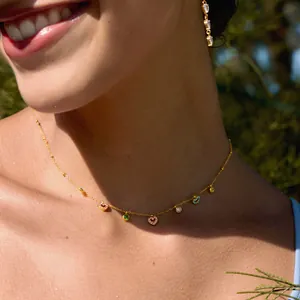 Nahaufnahme einer goldenen Titanstahlkette mit bunten Herz- und Rundanhängern