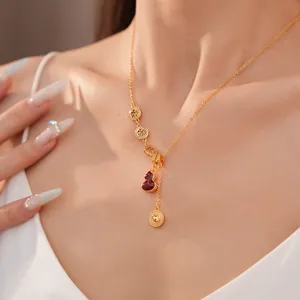 Close-up of a 18k gold plated necklace with red gourd and Fu character charms