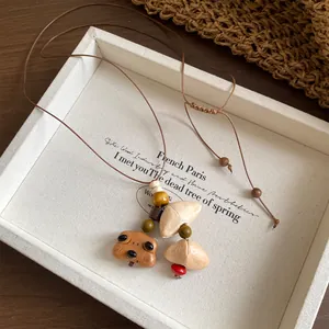 Close-up of vintage handmade wooden necklace with bear pendant and shells in a tray