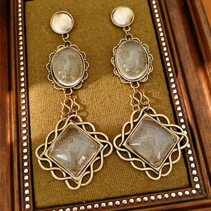 Macro shot of vintage gold earrings with oval and rhombus lace borders