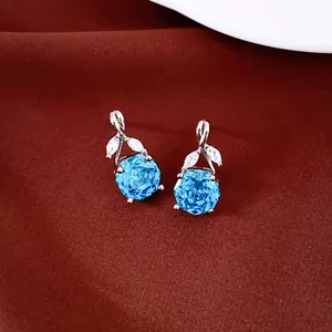 Detailweergave van de blauwe roos zirkonia oorknopjes met fonkelende bladaccenten.