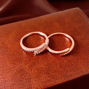Macro detail of two rose gold adjustable rings with cubic zirconia pavé on leather