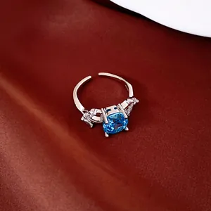 Detailweergave van verstelbare zilveren ring met blauwe zirkoon op satijn