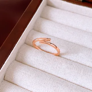 Close-up of elegant minimalist rose gold open ring displayed in a velvet jewelry box.