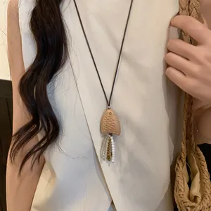Vintage ethnic style necklace with wooden fish pendant and shell tassels on leather cord