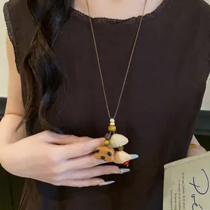 Detail of retro ethnic necklace with wooden bear and shell pendants on a brown dress
