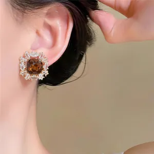 Vue détaillée d'une boucle d'oreille carrée en plaqué or 18K avec une pierre ambrée