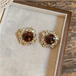 Vue détaillée des boucles d'oreilles carrées plaquées or 18 carats avec pierre brune