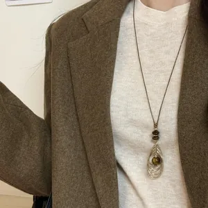 Collier pendentif œil de tigre vintage avec cordon marron sur tenue style Maillard