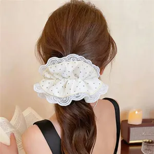 Vue arrière détaillée d'un mannequin portant un chouchou blanc à pois avec dentelle