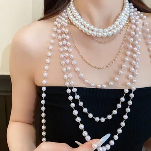 Detailopname van een elegante meerlaagse parel- en gouden ketting gedragen door een model