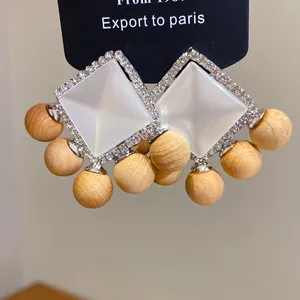 Close-up of French vintage earrings with rhinestone resin and wooden beads