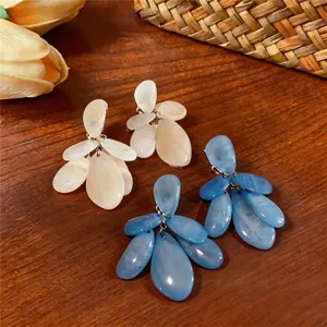 Pendientes de gota de resina veteada estilo vacaciones disponibles en azul y crema.