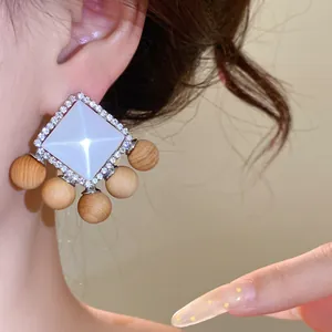 Detailed macro view of French retro earrings with white resin diamond and wood beads