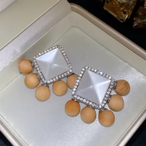 Close-up of French retro earrings with resin square and wooden beads