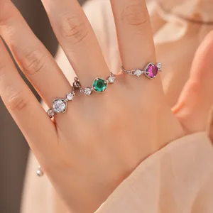 Detailopname van drie elegante ruitvormige zirkonia-kettingringen in diverse kleuren