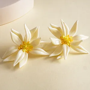 Detailansicht der übergroßen cremefarbenen Resin-Blumenohrringe mit gelben Kristallen