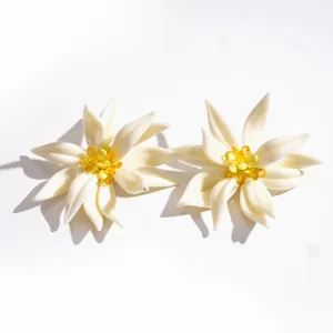 Elegante weiße Harzblumen-Ohrstecker mit leuchtend gelben Kristall-Mittelpunkten