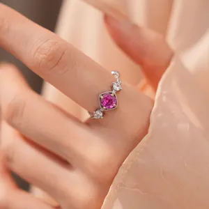 Detailopname van een elegante ring met een stralende roze edelsteen in het midden.