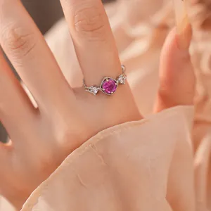 Close-up van een elegante ring met roze zirkoon op een zachte perzikkleurige achtergrond