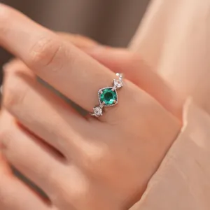 Gedetailleerde macro-opname van een elegante zilveren ring met een groene zirkoon edelsteen.