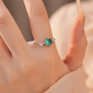 Detailopname van een zilveren ring met een schitterende groene ruitvormige zirkoon.