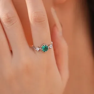Detailopname van een elegante mode ring met groene ruitvormige zirkoon en heldere stenen