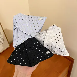 Close-up van drie Koreaanse haarklemmen met polkadots in blauw, wit en zwart